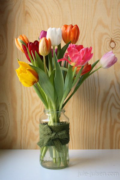 Tulpen in mit Spitzenband verziertem Haushaltsglas Tulpen in mit Spitzenband verziertem Haushaltsglas