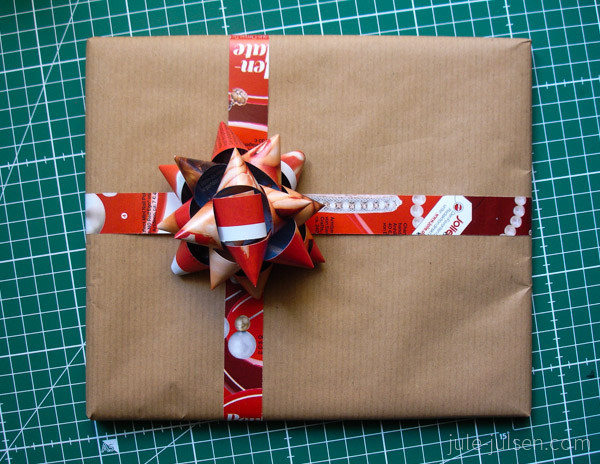 Geschenk mit selbst gebastelter Schleife aus altem Zeitschriftenpapier Geschenk mit selbst gebastelter Schleife aus altem Zeitschriftenpapier