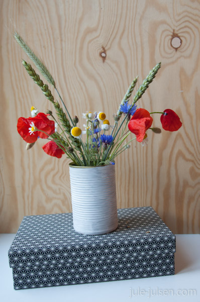 schwarz-weisse Pappbox auf der ein bunter Blumenstrauss steht schwarz-weisse Pappbox auf der ein bunter Blumenstrauss steht