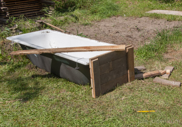 alte Wanne mit dem ersten Teil der Holzummantelung davor