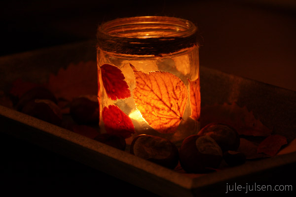 altes Marmeladenglas beklebt mit Herbstblättern und Teelicht im Dunkeln altes Marmeladenglas beklebt mit Herbstblättern und Teelicht im Dunkeln