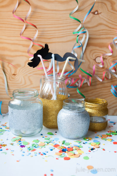 mit glitzer beklebte marmeladenglaeser, schnurrbaerte fuer strohhalme und selbst gemachtes konfetti