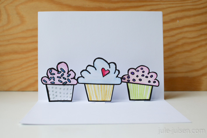 Innenseite der selbstgemachten Geburtstagskarte mit drei bunten Cupcakes, die sich beim Öffnen aufstellen Innenseite der selbstgemachten Geburtstagskarte mit drei bunten Cupcakes, die sich beim Öffnen aufstellen