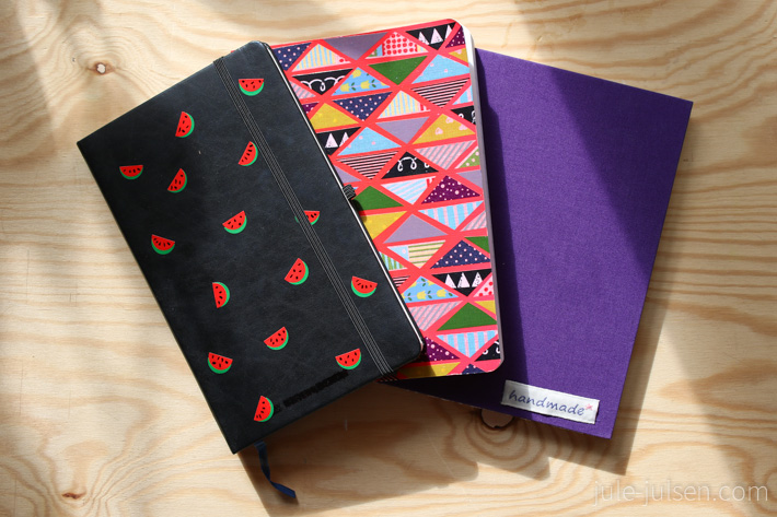 drei verzierte Notizbuecher: Melonendesign, Muster aus buntem Washi Tape Dreieicken und Stoffumschlag mit Aufnäher