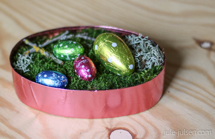 eierfoermiges Osterkoerbchen mit Moos und bunten Schokoeiern eierfoermiges Osterkoerbchen mit Moos und bunten Schokoeiern