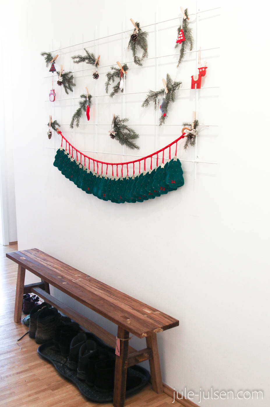 Pflanzgitter mit weihnachtlicher Dekoration aus Tannengrün, Anhängern und Adventskalender