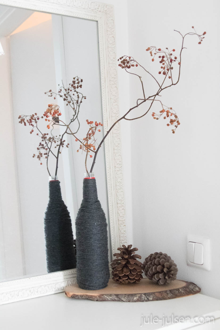 schlichte Weihnachtsdeko aus einer Wollvase mit Beerenzweig und großen Pinienzapfen schlichte Weihnachtsdeko aus einer Wollvase mit Beerenzweig und großen Pinienzapfen